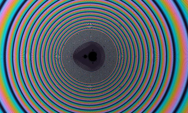 A tiny copy of the Mandelbrot set inside a moiré of many coloured rings